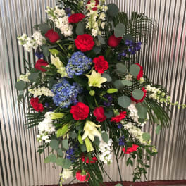 Standing floral spray with red, white, blue, and yellow flowers