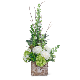 White roses and green hydrangeas in a birch bark container