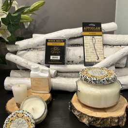 Assorted candles and fragrance products arranged on wood slices