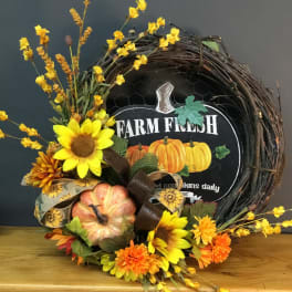 Fall wreath with sunflowers, orange blooms, and pumpkins