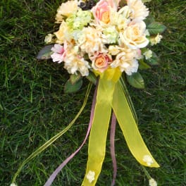 Pastel bouquet of roses and daisies with long yellow ribbons