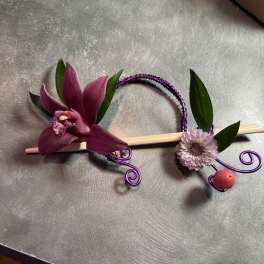 Purple orchid and small lavender flower on a decorative hairpin