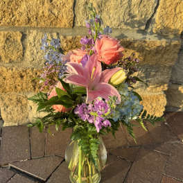 Mixed bouquet with pink lilies and roses in a glass vase