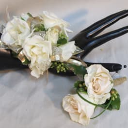 White rose corsage with ribbon on a black mannequin hand