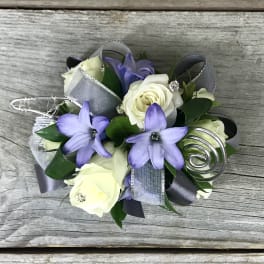 Corsage with white roses and purple flowers on silver ribbon