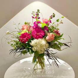 Mixed pink and white flower arrangement in a clear glass vase