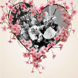 Heart-shaped floral design with pink blossoms around a black-and-white bouquet