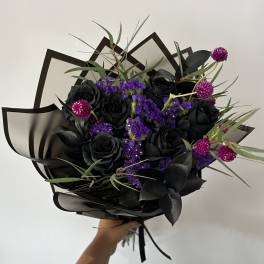 Black rose bouquet with purple filler flowers and dark foliage