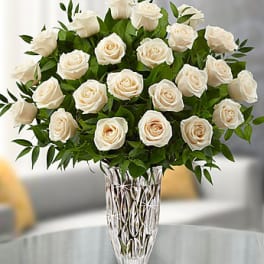 White roses arranged in a clear glass vase