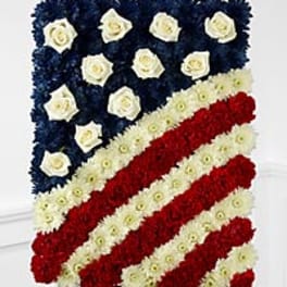 Floral tribute arranged as an American flag with red, white, and blue flowers