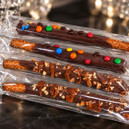 Four chocolate-covered pretzel rods in clear plastic sleeves