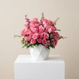 Pink roses arranged in a white geometric vase