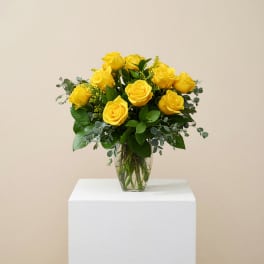 Yellow roses arranged in a clear glass vase
