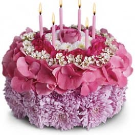 Pink floral cake with lit candles