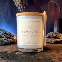 Labeled candle in a glass jar with a wooden lid and spoon