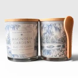 Two glass candles with wooden lids and a spoon beside them