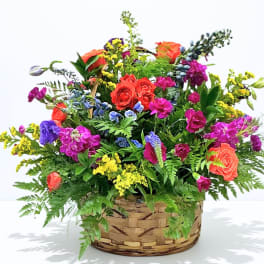Colorful mixed flower arrangement in a woven basket