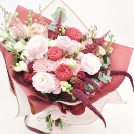 Pink and white mixed bouquet wrapped in burgundy paper