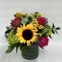 Sunflower and pink rose arrangement in a green vase