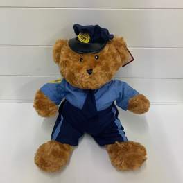 Teddy bear dressed in a blue firefighter uniform and hat