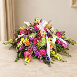 Colorful bouquet of roses, hydrangeas, and snapdragons with white ribbons