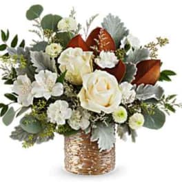 White roses and mixed blooms in a woven basket vase