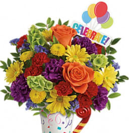 Colorful bouquet in a decorated vase with balloons and a "Celebrate!" sign