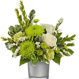 Green and white floral arrangement in a clear glass vase