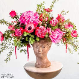 Pink floral crown on a sculpted head bust