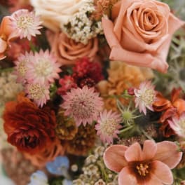 Peach roses and pink star-shaped flowers in a mixed bouquet