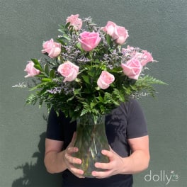 Pink roses in a glass vase held by a person