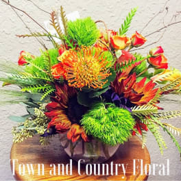Bright mixed bouquet with orange and red flowers in a glass vase