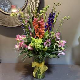 Colorful mixed bouquet in a glass vase with a yellow ribbon