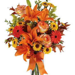 Orange lilies and roses with yellow daisies in a ribbon-tied bouquet