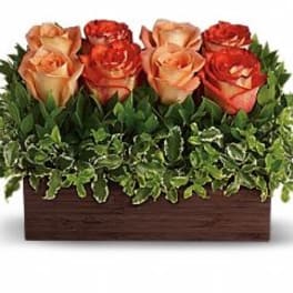 Arrangement of orange roses in a rectangular wooden box