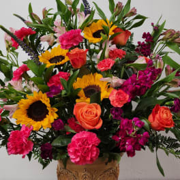 Mixed bouquet with sunflowers, roses, carnations, and alstroemeria in a vase