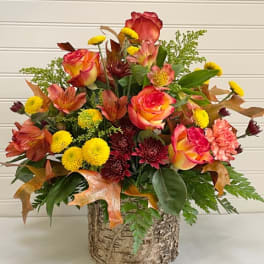 Mixed bouquet of roses, alstroemeria, and mums in a birch-style container