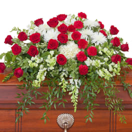 Red roses and white flowers arranged on a casket