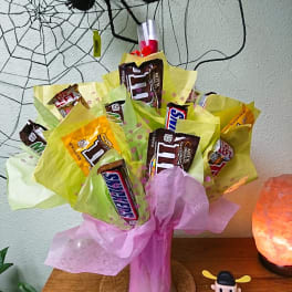 Bouquet of candy bars wrapped in pink and yellow tissue paper