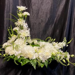 White floral arrangement with a tall central spray and low spread of blooms
