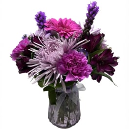 Purple and pink mixed bouquet in a clear glass vase