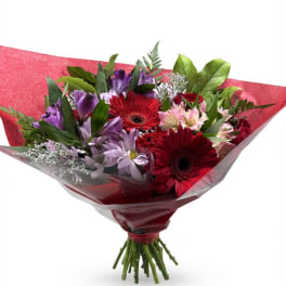 Bouquet of red and purple flowers wrapped in red paper