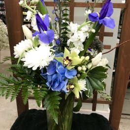 Blue and white floral arrangement in a glass vase