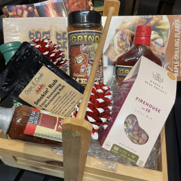 Gift basket with grilling sauces, seasonings, and a wooden utensil