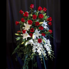 Standing floral spray of red roses, white lilies, and white orchids