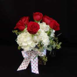 Bouquet of red roses and white hydrangeas with a polka-dot ribbon