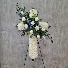 White and blue floral standing cross on an easel