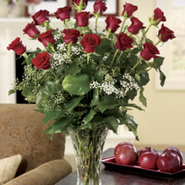 Red roses arranged in a clear glass vase