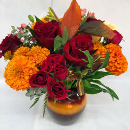 Red roses and orange marigolds arranged in a vase