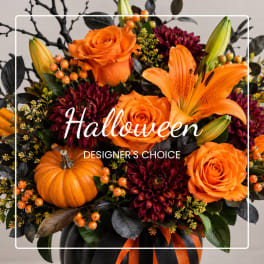 Orange roses and lilies with dark mums and a pumpkin in a vase